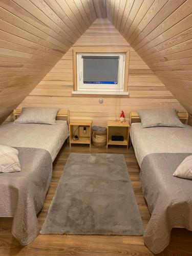 two beds in a room with a window at Tiny House Cēsis in Cēsis