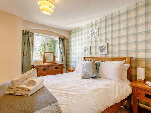 a bedroom with a large white bed and a window at 2 Bed in Combe Martin 86938 in Berrynarbor