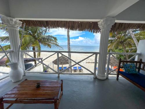 a living room with a view of the beach at The African Paradise Beach Hotel in Bwejuu
