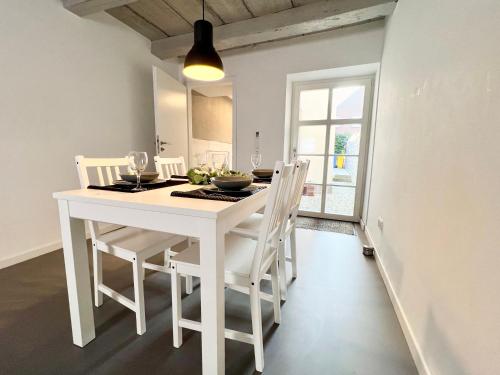 ein weißer Esstisch und Stühle in einem Zimmer in der Unterkunft Historisches Kontorhaus, Zentral, 2Zi., Netflix! in Emden