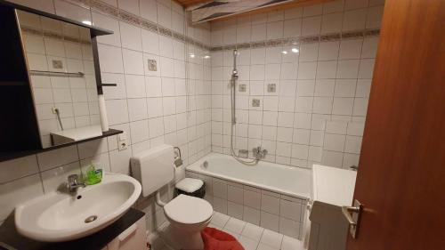 La salle de bains est pourvue d'un lavabo, de toilettes et d'une baignoire. dans l'établissement Ferienwohnung Ünal, à Prien am Chiemsee