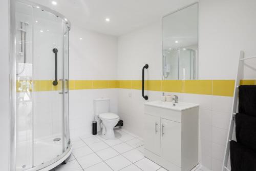 a bathroom with a shower and a toilet and a sink at Brand New Large Studio in Sheffield