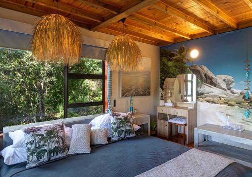 Un dormitorio con una cama con almohadas. en Villa Mtati, en Port Alfred