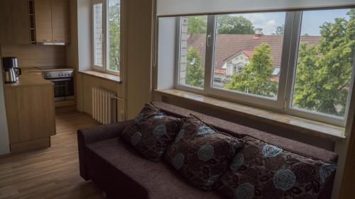 - un salon avec un canapé et 2 grandes fenêtres dans l'établissement Kaubi Guest Apartment, à Kuressaare