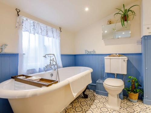 a bathroom with a white tub and a toilet at 1 Bed in Braunton 86987 in Braunton