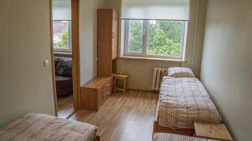 a small room with two beds and a window at Kaubi Guest Apartment in Kuressaare