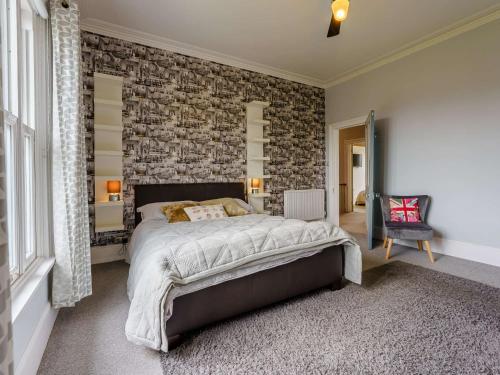 a bedroom with a large bed with a brick wall at 5 Bed in Sandown 87008 in Sandown