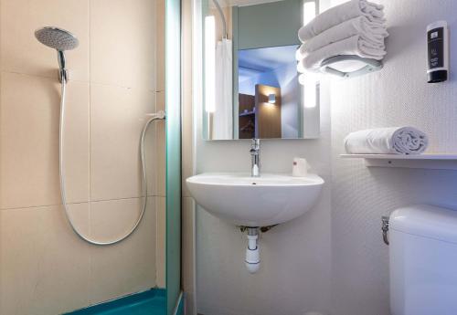 a bathroom with a sink and a shower and a mirror at B&B HOTEL CHARTRES Le Coudray in Chartres
