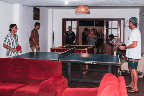 a group of people in a room with a pool table at Nômades Beach - Adventure Hostels in Florianópolis