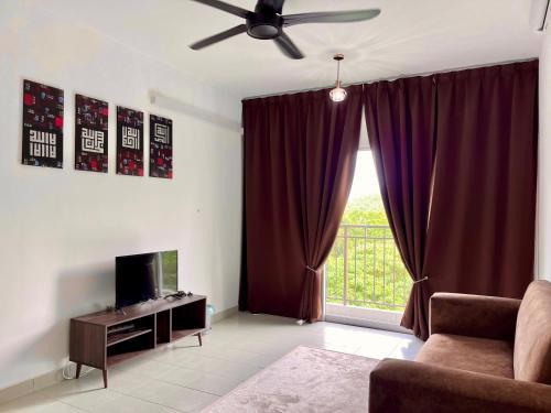 a living room with a couch and a ceiling fan at Omak Kito Homestay Melaka in Kampong Alor Gajah
