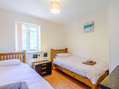 a bedroom with two beds and a dog laying on the bed at 2 bed property in Bala 86963 in Llandderfel