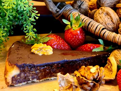 a chocolate pie sitting on a table next to strawberries at Domaine de La Rhonie in Meyrals