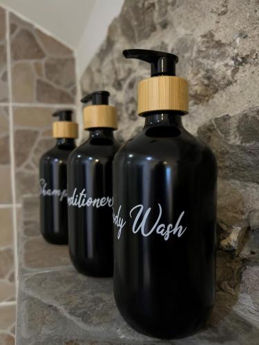 three black bottles are sitting on a counter at Gîte Rubis - JACUZZI - Pairi Daiza - 6 pers in Brugelette