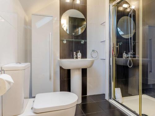 a bathroom with a toilet and a sink and a shower at 3 Bed in Bude 87256 in Bude