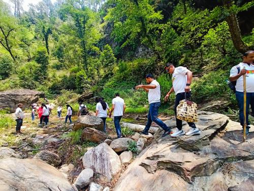 a group of people walking on some rocks at JMT Eco-Binsar by StayApart in Panuānaula