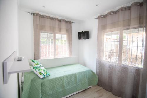 1 dormitorio con 1 cama verde y 2 ventanas en La Deseada, en Murcia