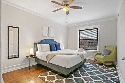 - une chambre avec un lit, un ventilateur de plafond et une chaise dans l'établissement Enchanting 2BR Apt with In-unit Laundry - 53rd St 3, à Chicago