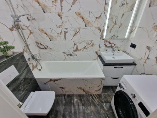 a bathroom with a sink and a tub and a toilet at KSY Hotel Family Stay in Tbilisi City