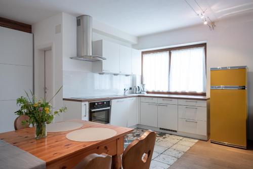 a kitchen with a wooden table and a yellow refrigerator at Residenz Feldmühle unterhalb der Burg Taufers in Campo Tures