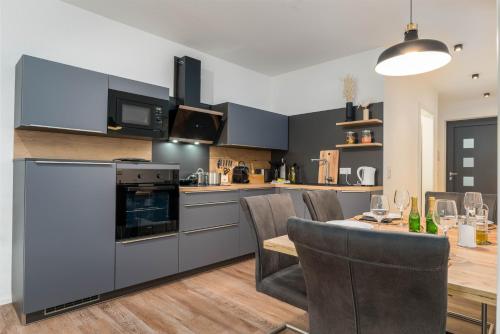 a kitchen and dining room with a table and chairs at Vivamosel: Appartement mit Mosel & Burgblick - Balkon - Parken - Aufzug - Fahrradraum in Cochem