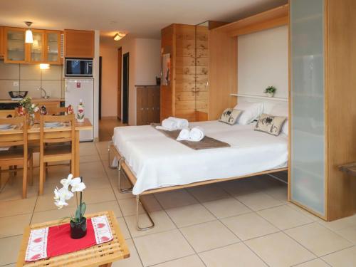 1 dormitorio con 1 cama grande y cocina en Apartment Quille du diable 19 by Interhome, en Nendaz