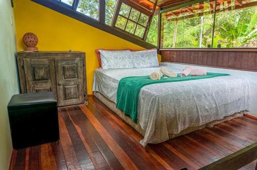 a bedroom with a bed and a window at Sítio Abaetetuba - Toda Paz do Universo in Nova Friburgo