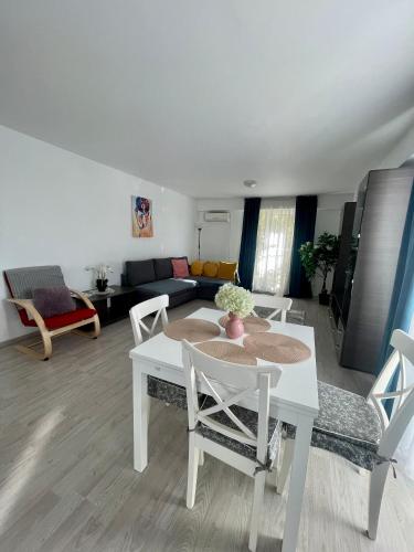 a living room with a white table and chairs at Fly Airport Residences & Therme-SELF CHECK-IN in Otopeni