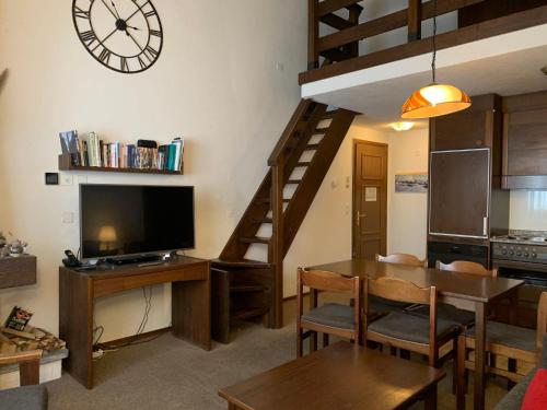 a living room with a dining room table and a clock at Apartment Residenza Chesa Margun 59-6 by Interhome in Surlej