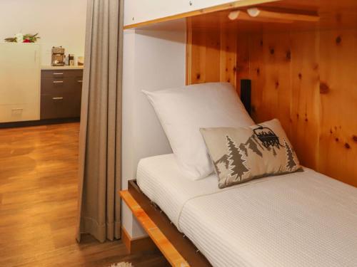 a bedroom with a bed with a wooden wall at Apartment Chaedoz 24-1 by Interhome in Nendaz