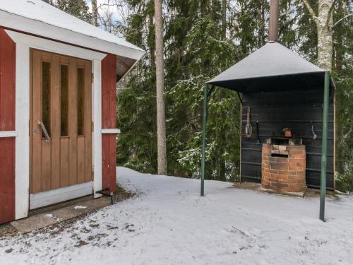 a snow covered building with a stove in front of it at Holiday Home Mäkimökki by Interhome in Palikainen