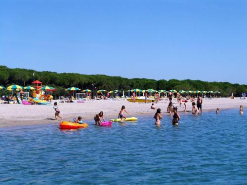 een groep mensen in het water op een strand bij Holiday Home Camping Thurium by Interhome in Marina di Schiavonea