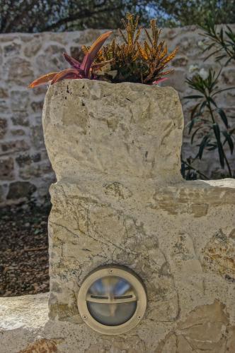 a stone wall with a window with a plant in it at Unity Villa in Pilaroú