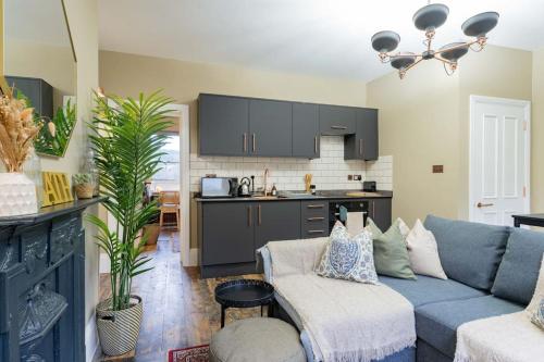 sala de estar con sofá azul y cocina en Stunning Boutique Flat in Central Location - Beatrice en Bath