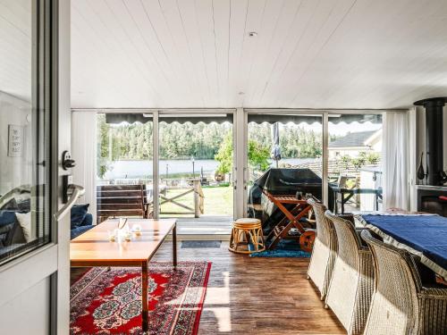 a living room with a table and a piano at Chalet Toltorp - SDM100 by Interhome in Katrineholm