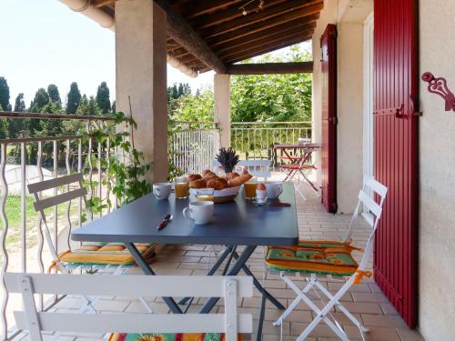 une table et des chaises sur un porche avec un bol de nourriture dans l'établissement Holiday Home Mas de la Gourmette by Interhome, à Châteaurenard