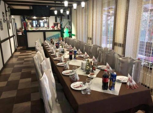 a long table in a room with chairs and bottles of alcohol at Beregynia in Zhdenievo