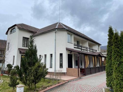 a white house with a black roof at Beregynia in Zhdenievo