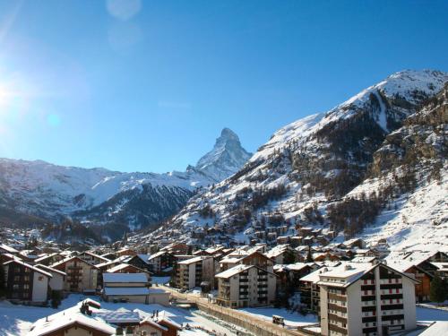 une ville dans les montagnes avec des montagnes enneigées dans l'établissement Apartment Siesta by Interhome, à Zermatt
