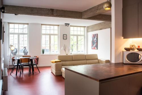 eine Küche und ein Wohnzimmer mit einem Sofa und einem Tisch in der Unterkunft The Industria - Stylish in Historical Center in Antwerpen