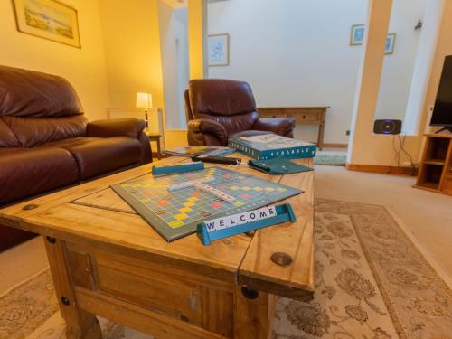 a living room with a table with a board game on it at Holiday Home Lodge Road-1 by Interhome in Inverness