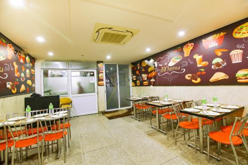 ein Restaurant mit Tischen und Stühlen in einem Zimmer in der Unterkunft The Nirvana Delhi Airport in Neu-Delhi