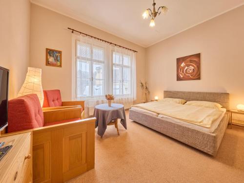 een slaapkamer met een bed, een bank en een tv bij Apartment Koreff-2 by Interhome in Janske Lazne