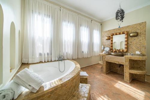 ein Badezimmer mit großer Badewanne und Waschbecken in der Unterkunft Villa Chems - Al Ouidane in Marrakesch