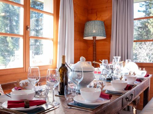 una mesa de comedor con copas y una botella de vino en Chalet Chalet Tetras by Interhome en Chesières