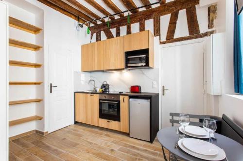 a kitchen with a dining table and a kitchen with a counter at Superb apartment- 4P- Montorgueil Nazareth in Paris