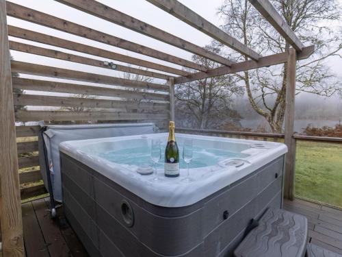 a hot tub with a bottle of wine in it at Chalet Lodge 4 by Interhome in Spean Bridge