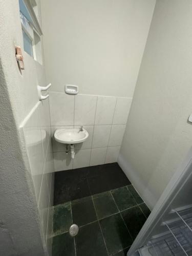 a small bathroom with a sink and a toilet at Quarto Central in Guararema