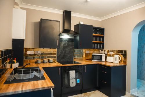 a kitchen with black cabinets and a stove at Billy's Place in Boston