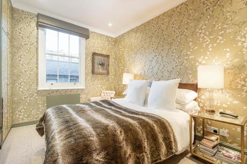 sypialnia z dużym łóżkiem i oknem w obiekcie JOIVY Elegant 1 bed flat in Chelsea w Londynie