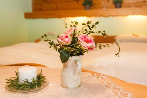 a vase filled with pink roses on a table at Ferienwohnung Hinterreiter in Ruhpolding
